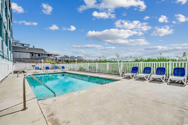 pool featuring fence and a patio area