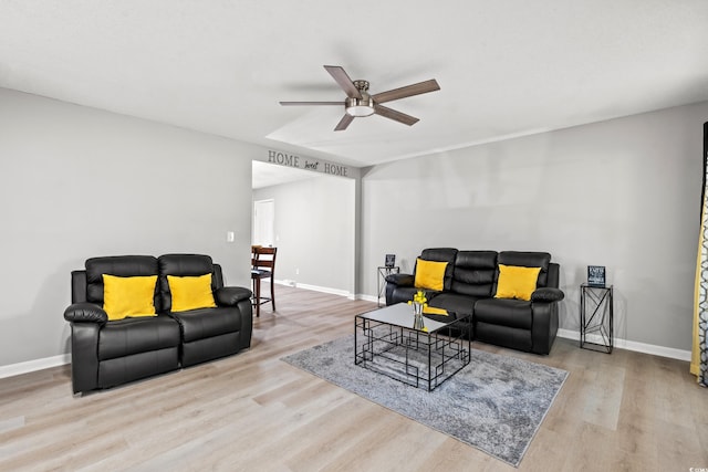 living room with ceiling fan and light hardwood / wood-style flooring