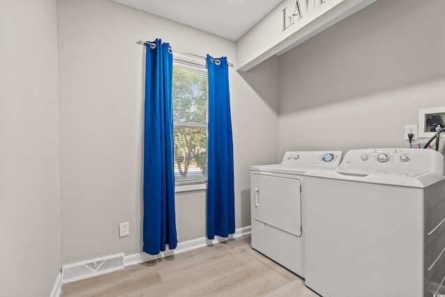 laundry area featuring light wood-type flooring and washing machine and dryer