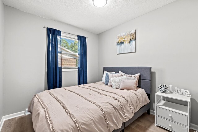 bedroom featuring a textured ceiling and hardwood / wood-style floors