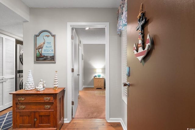 hall featuring light wood-type flooring and a textured ceiling