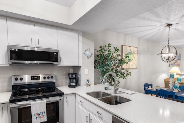 kitchen featuring white cabinetry, stainless steel appliances, an inviting chandelier, sink, and decorative backsplash