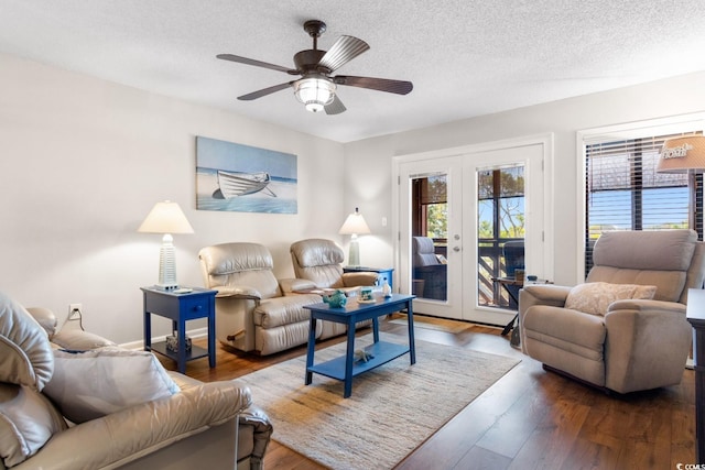 living room featuring french doors, dark hardwood / wood-style flooring, ceiling fan, and a textured ceiling