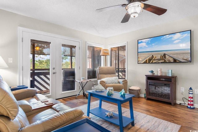 living room featuring hardwood / wood-style floors, ceiling fan, and a textured ceiling