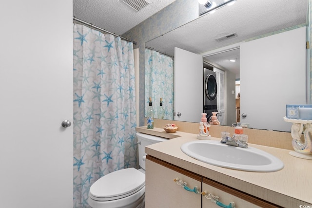 bathroom with toilet, stacked washing maching and dryer, a shower with curtain, vanity, and a textured ceiling