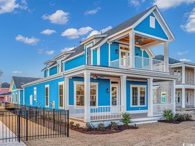 view of front facade featuring a porch, fence, a balcony, and a ceiling fan