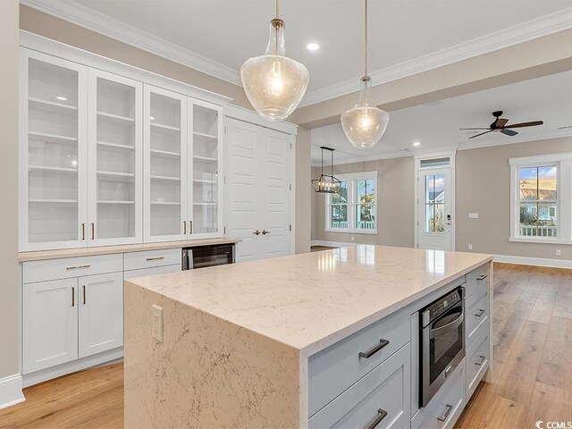 unfurnished living room featuring ornamental molding, dark hardwood / wood-style floors, ceiling fan with notable chandelier, and sink