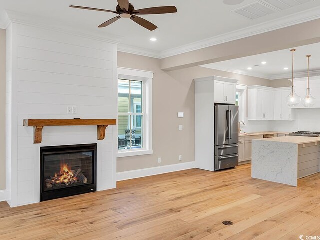 kitchen featuring light wood-type flooring, appliances with stainless steel finishes, a kitchen island, and sink