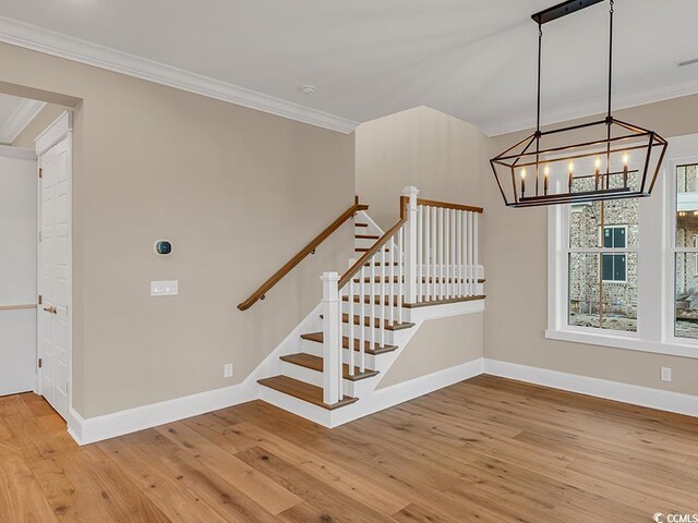 spare room featuring ceiling fan, ornamental molding, and light wood-type flooring