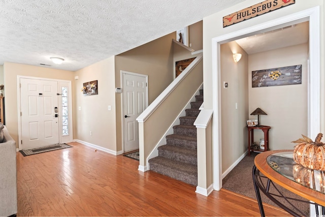 foyer with a textured ceiling and wood-type flooring