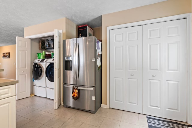 kitchen with a textured ceiling, washing machine and dryer, light tile patterned flooring, and stainless steel refrigerator with ice dispenser