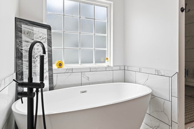 bathroom featuring tile walls and a washtub