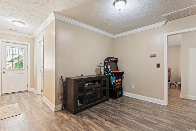 entryway with crown molding, a textured ceiling, and hardwood / wood-style floors