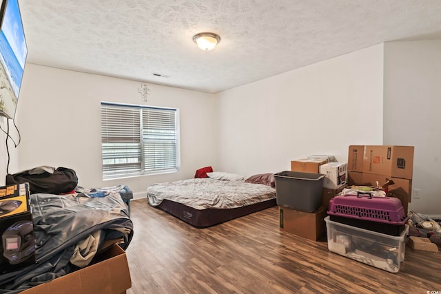 bedroom with a textured ceiling and hardwood / wood-style floors