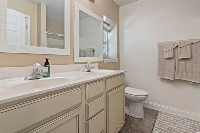 bathroom featuring a textured ceiling, vanity, toilet, and tile patterned floors