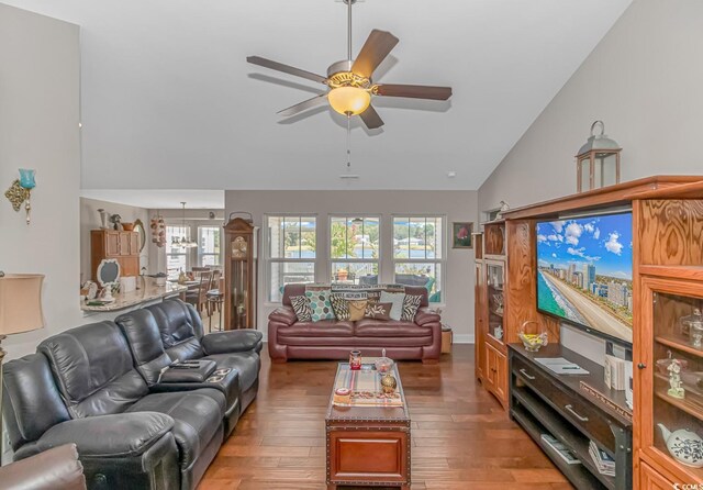 living room with dark wood-type flooring, vaulted ceiling, and ceiling fan