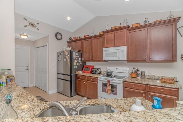 kitchen featuring white appliances, light tile patterned floors, sink, light stone countertops, and vaulted ceiling