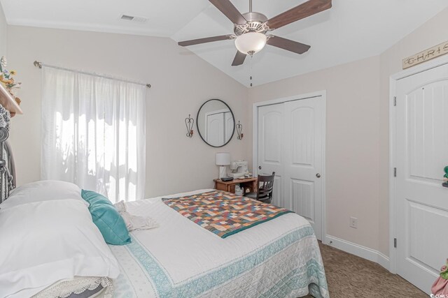 bedroom with lofted ceiling, a closet, ceiling fan, and light carpet