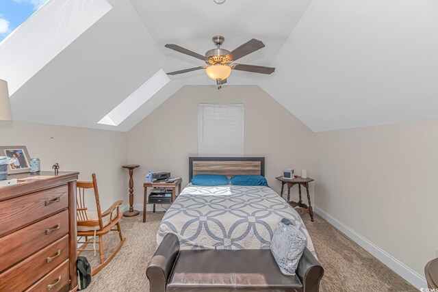 carpeted bedroom with ceiling fan and lofted ceiling with skylight