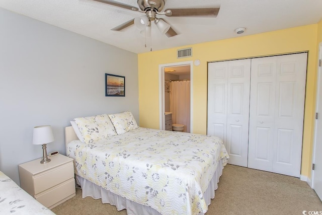 carpeted bedroom with connected bathroom, ceiling fan, and a closet