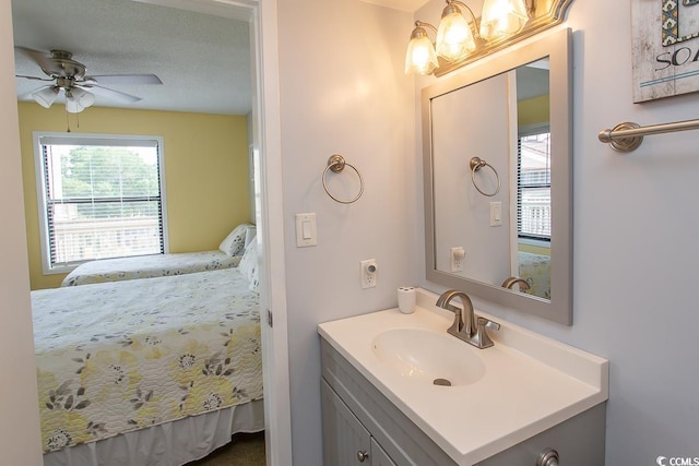 bathroom with a textured ceiling, vanity, and ceiling fan