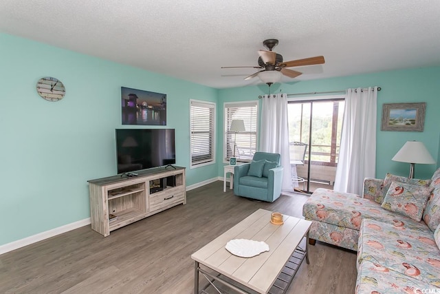 living room featuring ceiling fan, a textured ceiling, and hardwood / wood-style floors