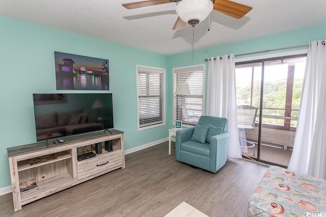 interior space with ceiling fan, a textured ceiling, and wood-type flooring