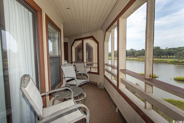 sunroom / solarium featuring a wealth of natural light and a water view