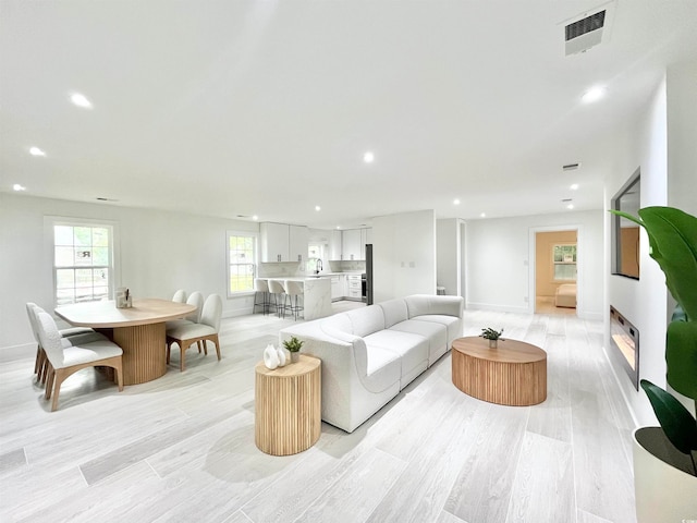 living room with sink and light hardwood / wood-style floors