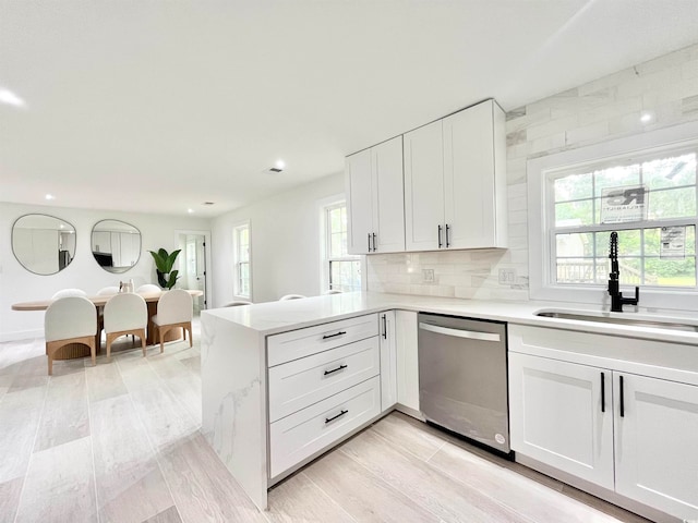 kitchen featuring dishwasher, light hardwood / wood-style floors, white cabinetry, and sink