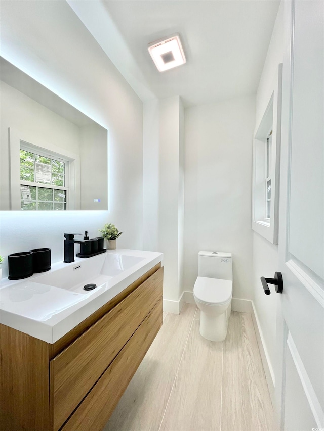 bathroom featuring vanity, toilet, and hardwood / wood-style flooring