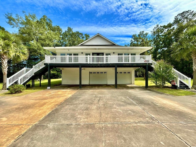 raised beach house featuring a wooden deck and a garage