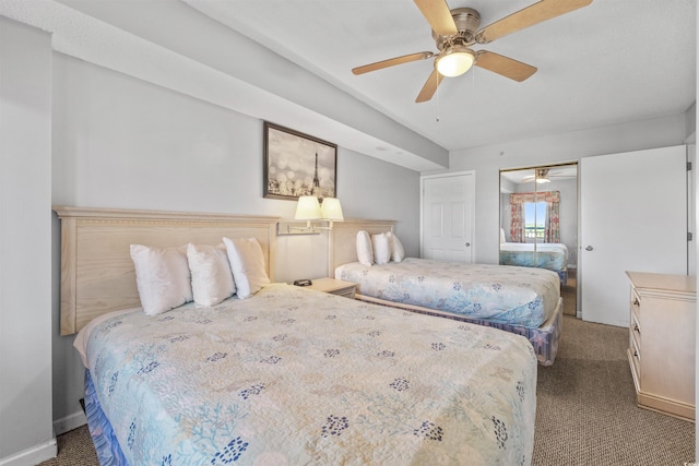 bedroom featuring dark carpet, ceiling fan, and a closet