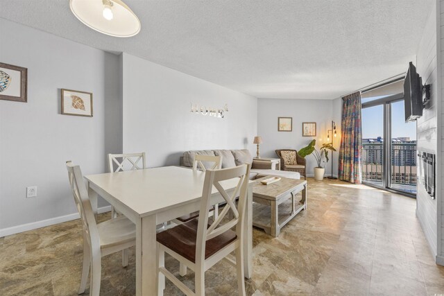 dining space with a textured ceiling and a wall of windows