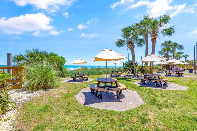 view of yard with a water view, a patio area, and an outdoor fire pit