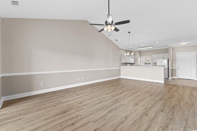 unfurnished living room featuring ceiling fan with notable chandelier, light hardwood / wood-style flooring, and high vaulted ceiling