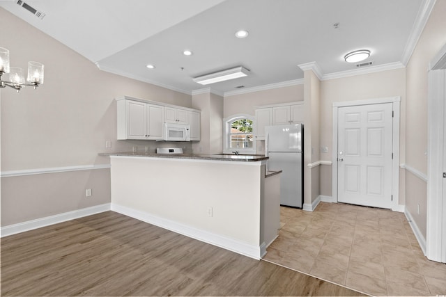 124 S Shore Blvd Unit 303, Longs, SC 29568 - kitchen featuring freestanding refrigerator, white microwave, a peninsula, white cabinets, and ornamental molding