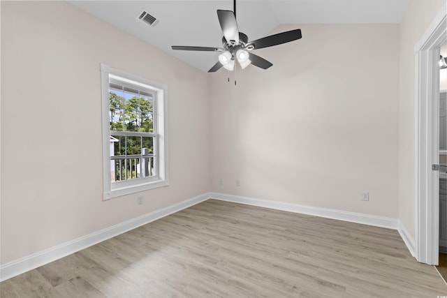 spare room with light wood-type flooring, vaulted ceiling, and ceiling fan