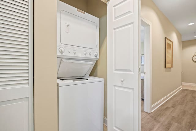 laundry area featuring stacked washer and dryer and light hardwood / wood-style floors