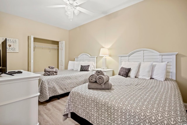 bedroom featuring light hardwood / wood-style floors, ceiling fan, and a closet