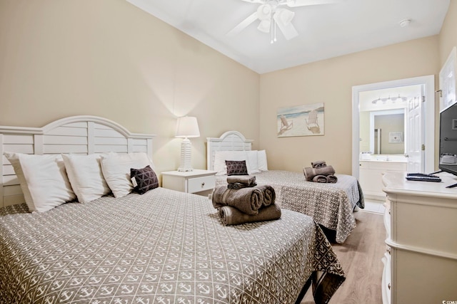 bedroom with light wood-type flooring, lofted ceiling, connected bathroom, and ceiling fan