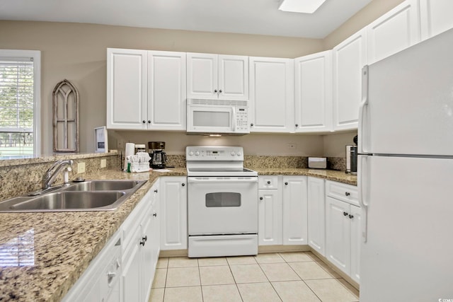 kitchen with white appliances, light stone countertops, sink, and white cabinets