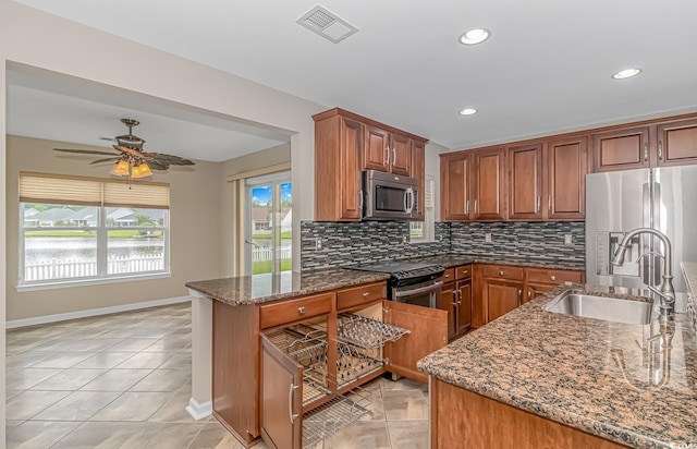 kitchen with ceiling fan, sink, backsplash, dark stone countertops, and appliances with stainless steel finishes