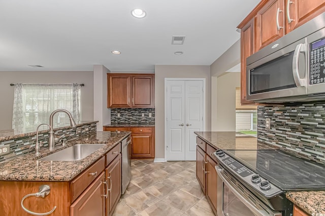 kitchen with decorative backsplash, dark stone countertops, sink, and appliances with stainless steel finishes