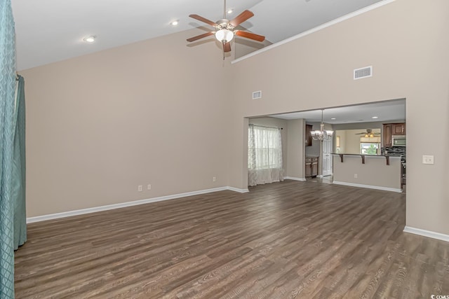 unfurnished living room with plenty of natural light, high vaulted ceiling, and dark wood-type flooring