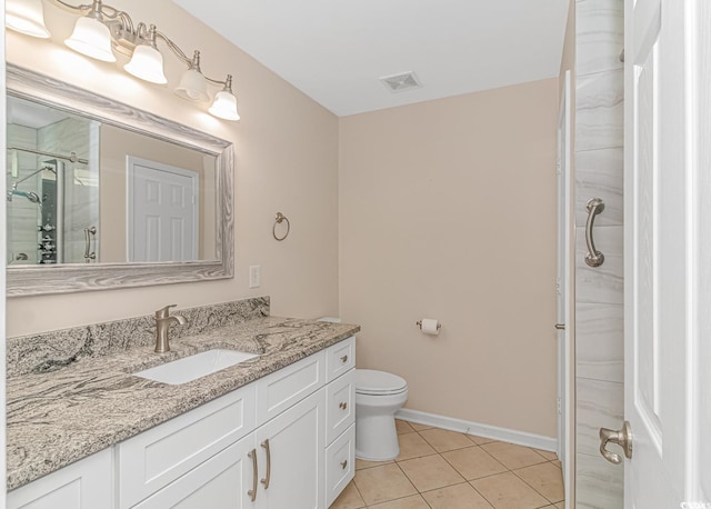 bathroom with toilet, tile patterned flooring, vanity, and walk in shower