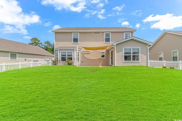 back of house with a lawn