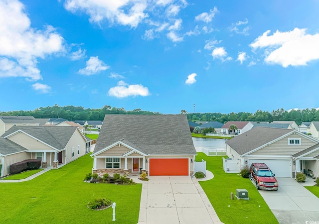 view of front of home featuring a water view, a garage, and a front lawn