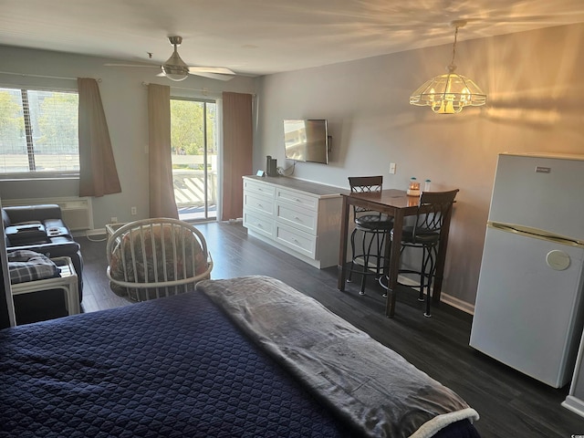 bedroom with ceiling fan with notable chandelier, access to exterior, dark hardwood / wood-style floors, and white fridge