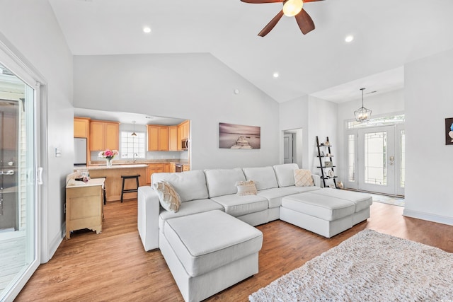 unfurnished living room featuring vaulted ceiling, light hardwood / wood-style floors, and ceiling fan